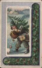 XMAS A child carrying a small Christmas tree behind him on his shoulder. Vintage picture