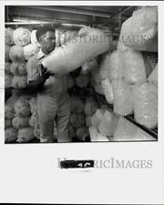 1976 Press Photo Gathol Griffin stacking bags of popcorn. - hpa12506 picture