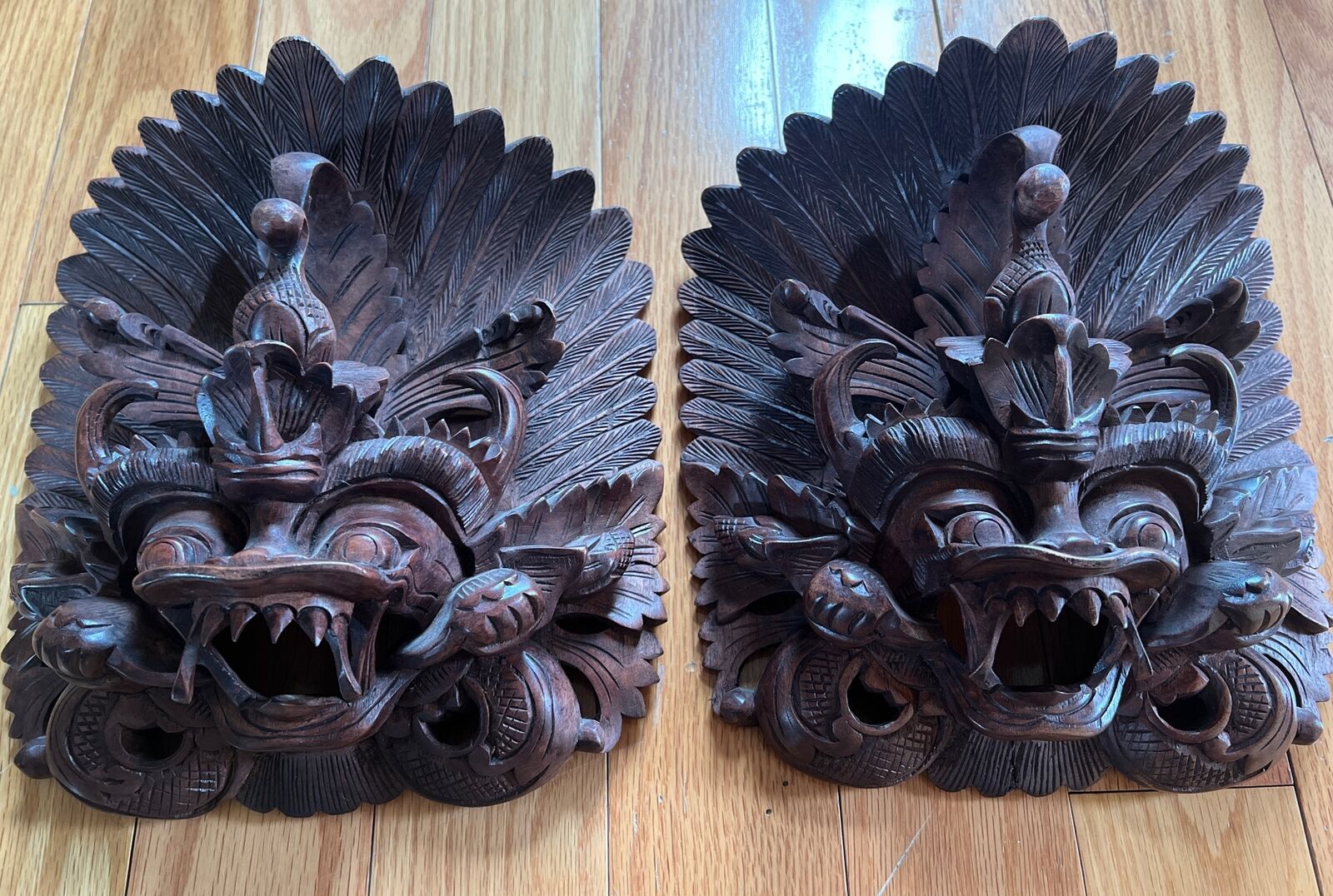 A pair of Balinese Garuda acacia wood masks carved by Indonesian craftsmen