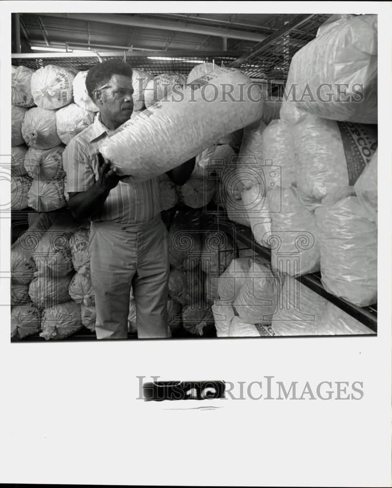 1976 Press Photo Gathol Griffin stacking bags of popcorn. - hpa12506