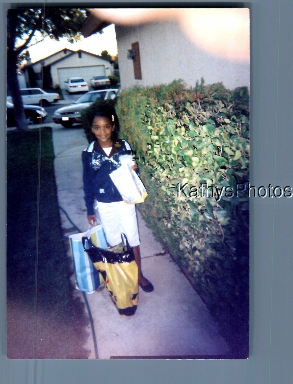 FOUND COLOR PHOTO J_1903 BLACK GIRL POSED WITH SHOPPING BAGS IN DRIVEWAY